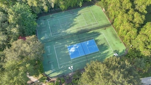 An aerial view of a tennis court surrounded by dense foliage. - Spacious 3BR retreat w/ pool access & park views (Kissimmee)