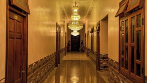 A long, polished hallway with a large, ornate chandelier hanging from the ceiling. - Cam Uyen Hotel (Tan Ha Lam Ha)