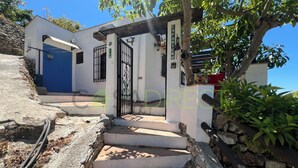 A villa with a blue door, a gated entrance, and a staircase leading to the main entrance. - Farmhouse in the Picturesque Village of Frigiliana (Frigiliana)