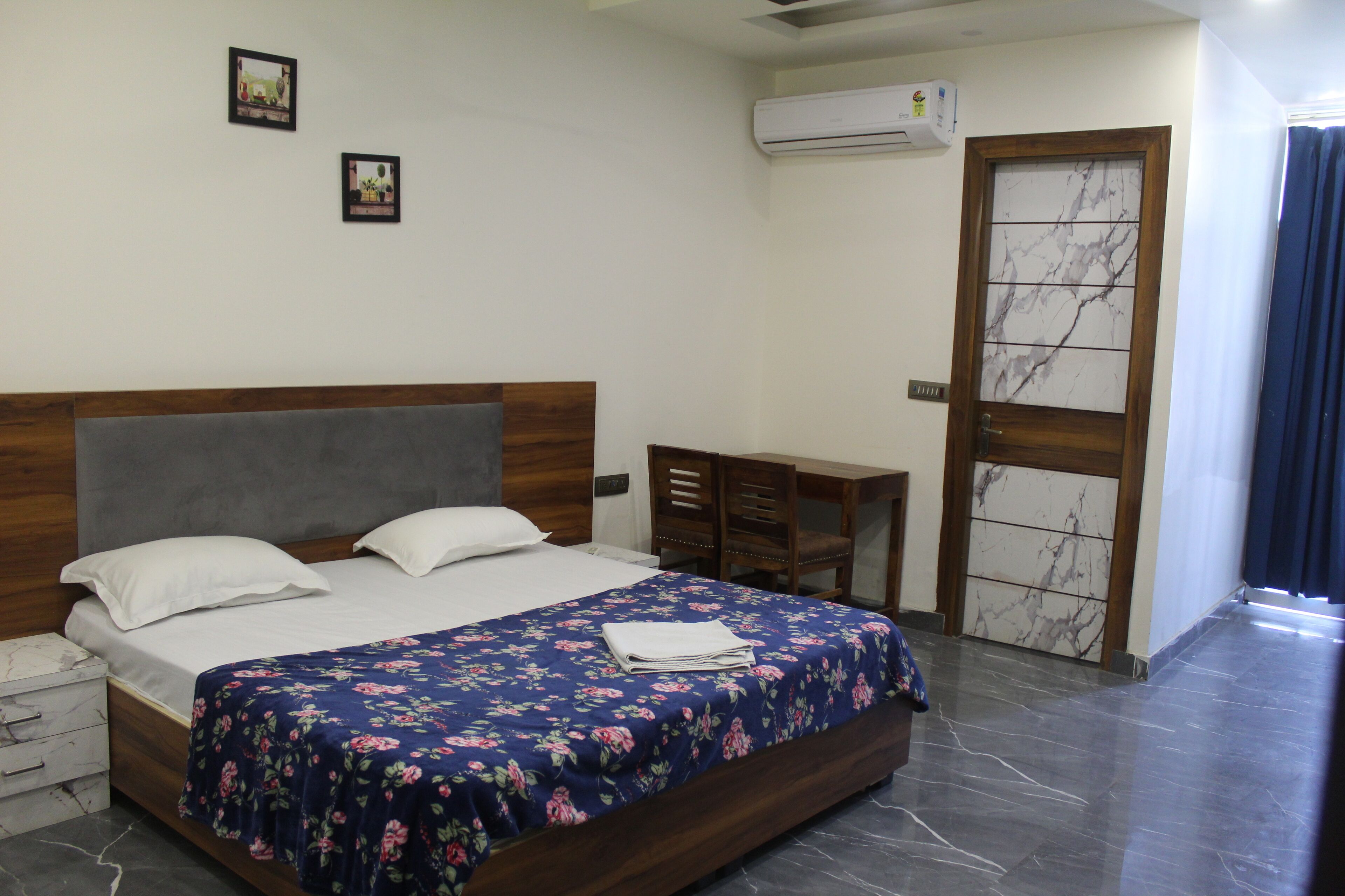 A bedroom with a bed, a desk, and a wardrobe.
