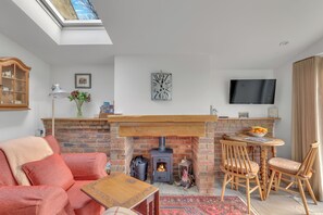 Un salon chaleureux avec une cheminée en briques, une table en bois et un canapé confortable.