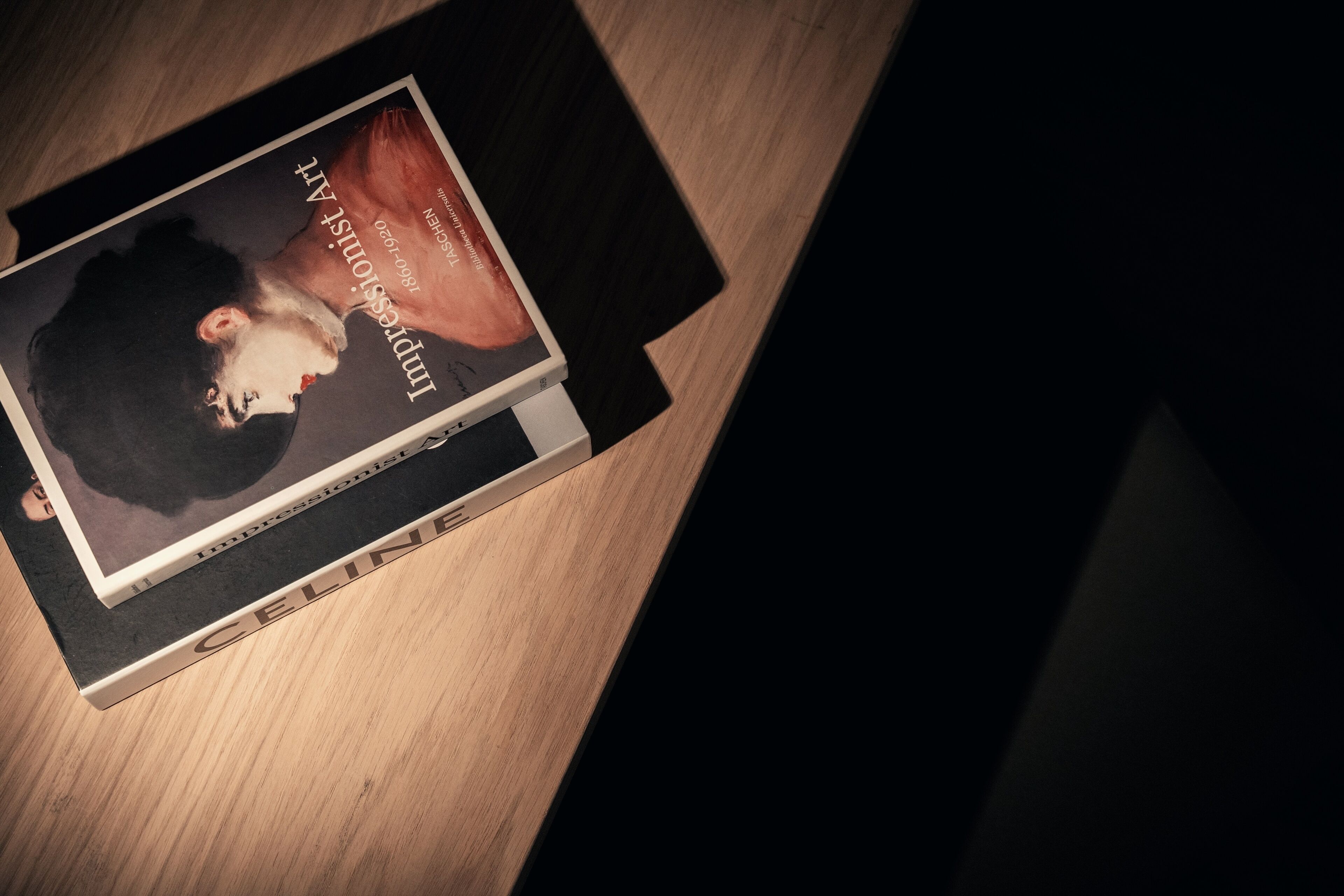 A book titled "Impressions of Art" on a wooden surface.
