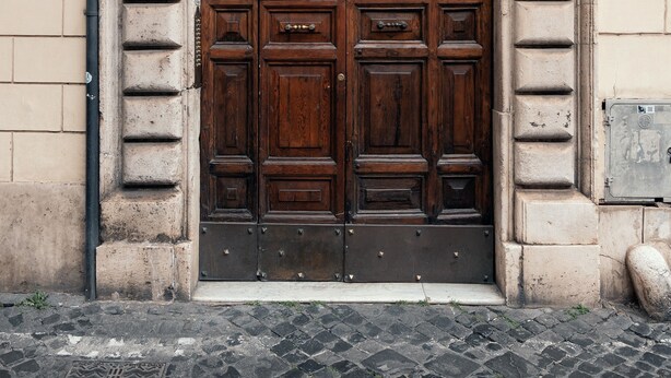 A large, ornate wooden door with a decorative arch and a shell motif above it. - VELVET GREY BOUTIQUE HOTEL ROMA (Rome)
