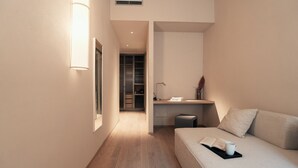 A modern hotel room with a wooden floor, a bed with a bedside table, a desk with a lamp, and a closet. - VELVET GREY BOUTIQUE HOTEL ROMA (Rome)