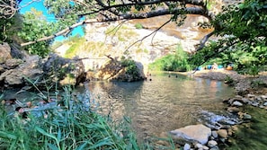 A natural setting with a clear stream, rocky terrain, and greenery. - Casa De Gasperi in Castellammare del Golfo (Castellammare del Golfo)