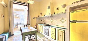Une cuisine équipée d’une table à manger, de chaises, d’une cuisinière et d’un réfrigérateur.