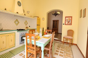Une cuisine équipée d’une table à manger pour deux personnes, d’un réfrigérateur et d’une cuisinière.