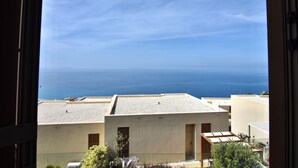 Vista del mar desde un balcón con cielo despejado.