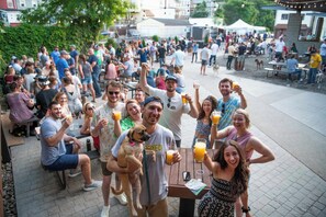 Un incontro all'aperto con persone sedute a tavoli, alcune con bevande in mano.