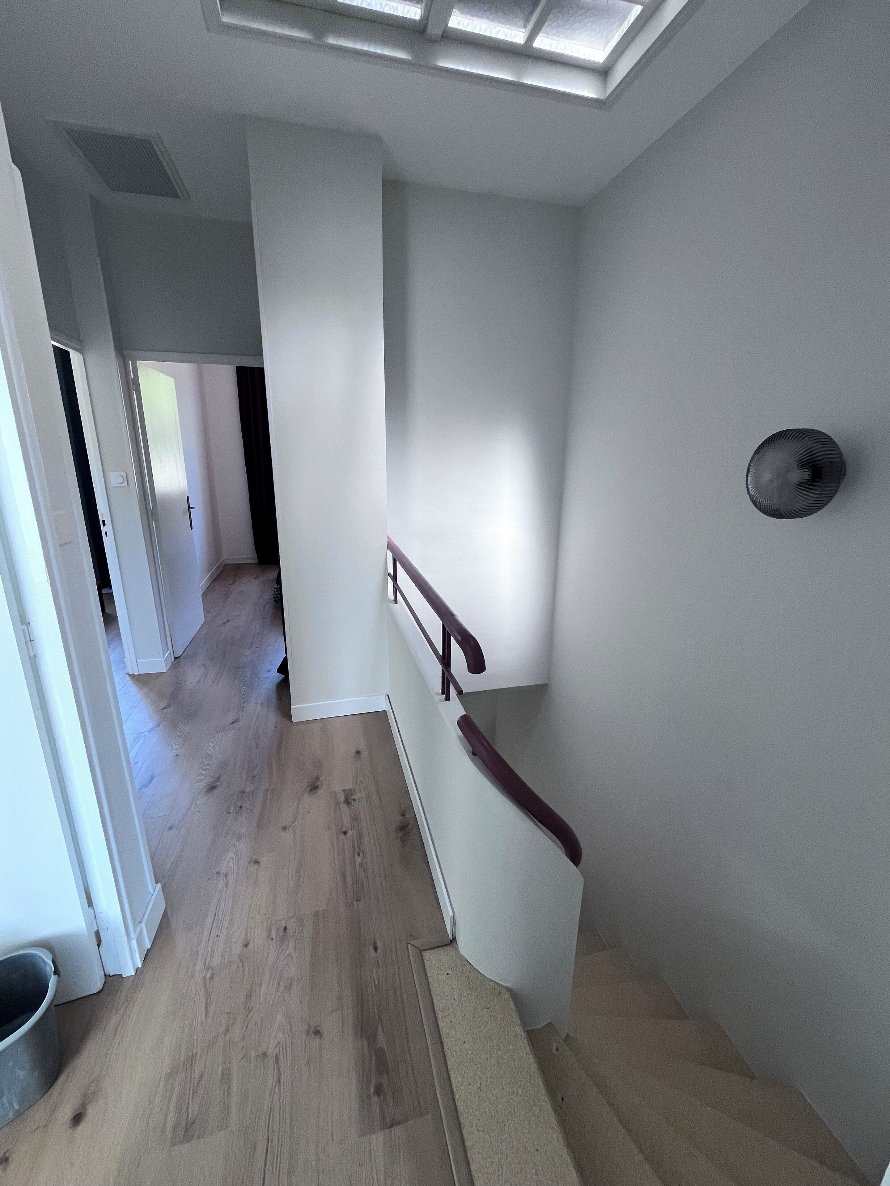 A staircase with a wooden handrail and a light-colored wall.