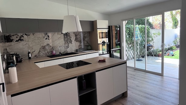 A modern kitchen with a marble backsplash, a wooden countertop, and a sliding glass door leading to a backyard. - House in Narbonne, ideal for Les Grands Buffets, with swimming pool and air-conditioning (Narbonne)