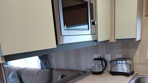 Una cocina compacta equipada con microondas, tostadora y lavavajillas integrados.