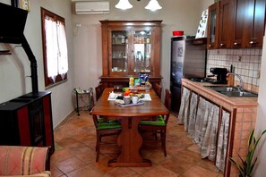 Une cuisine équipée d’une table à manger, de chaises, d’un réfrigérateur et d’une cuisinière.