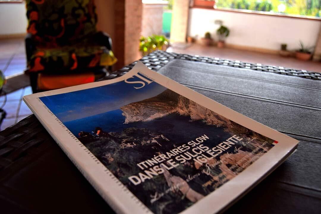 Un magazine posé sur une table, avec en arrière-plan un paysage montagneux.