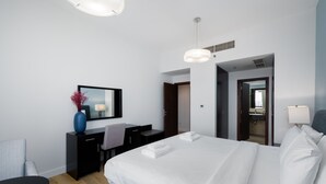 Een moderne hotelkamer met een groot bed, een bureau en een stoel.