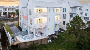 A multi-story building with balconies, a swimming pool, and a well-maintained lawn. - LakeFront w/ LSV, Bikes, Pool, & Game Room! STEPS to Beach! Sleeps 20, Pet Friendly! (Santa Rosa Beach)
