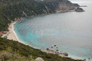 A coastal landscape with a beach, rocky outcrops, and a small settlement with buildings. - Cozy Superior Seaview Nest - Kefalonia Garden Gem (Kefalonia)