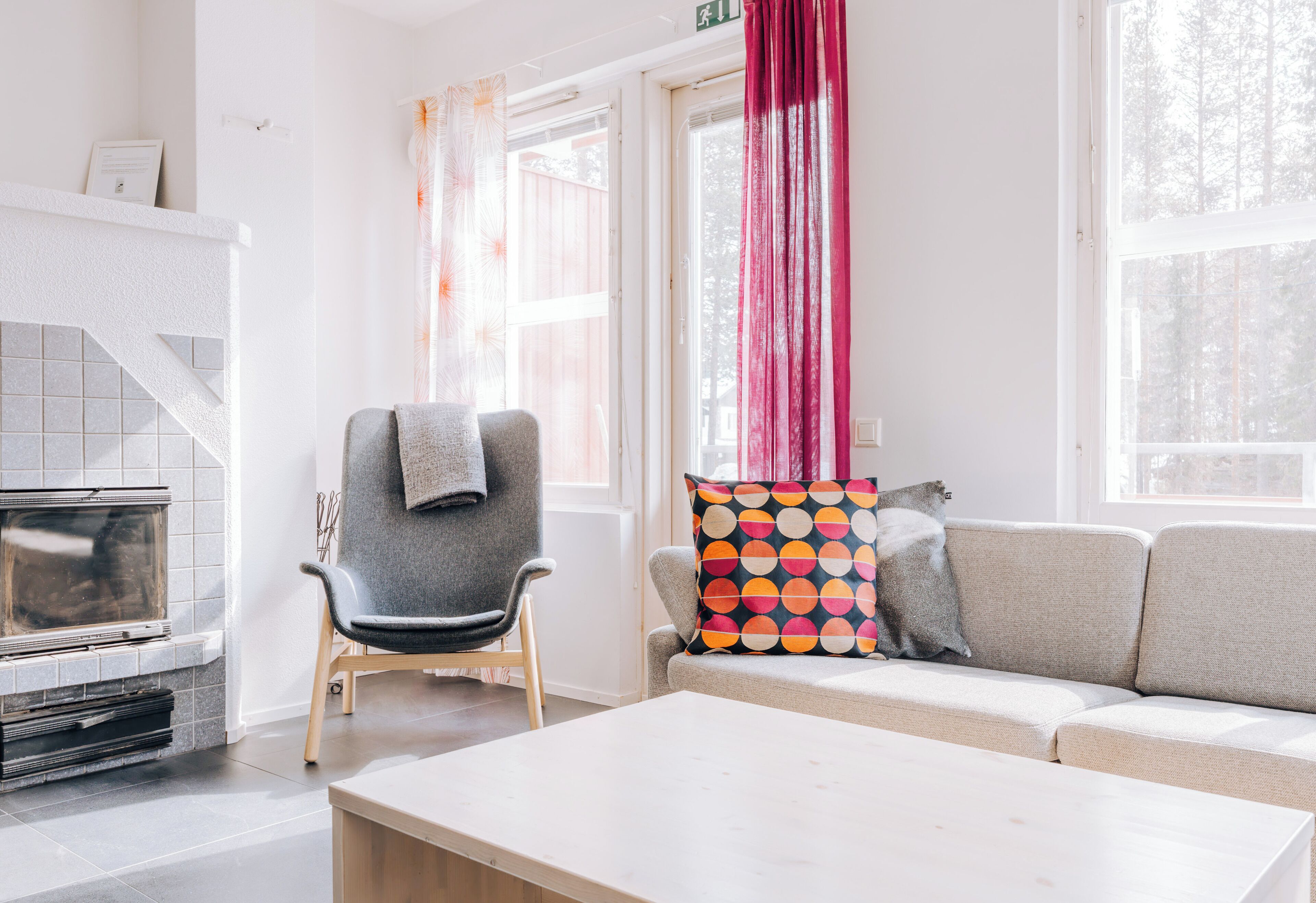 Ein Wohnzimmer mit Kamin, einer Couch, einem Sessel und einem Tisch.