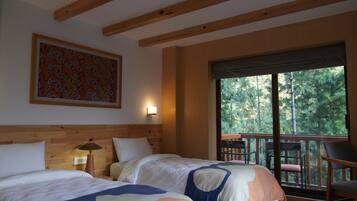 Quarto com duas camas, teto de madeira, um quadro na parede, janela com vista para árvores e uma varanda com cadeira.