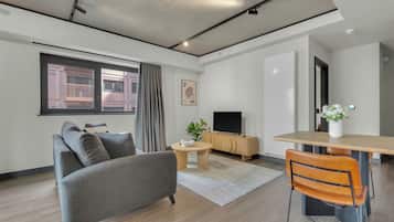 Apartamento com design assinado, 1 cama Queen, aceita animais de estimação, vista para a cidade | Área de estar | TV LED 40 polegadas com canais digitais