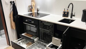 Eine moderne Küche mit Einbauofen, Geschirrspüler und Spüle.
