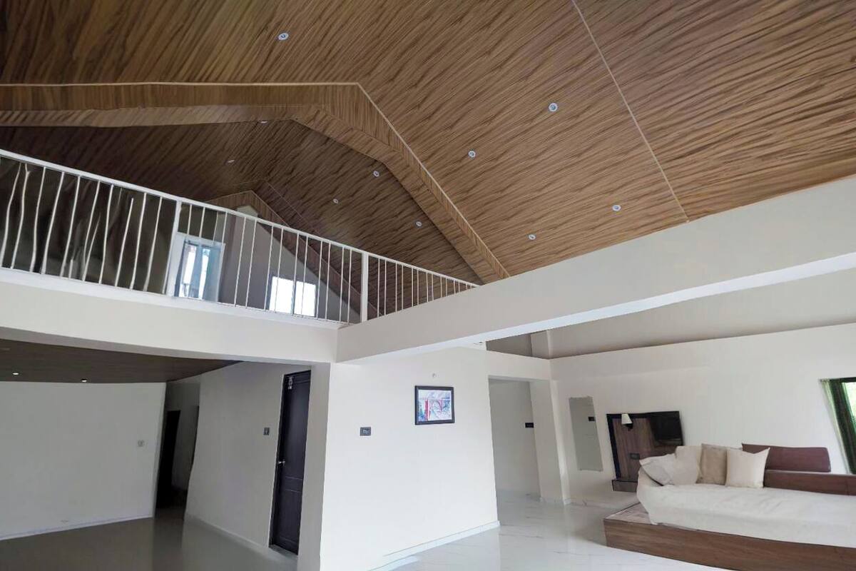 Un intérieur spacieux avec un plafond haut, un balcon et un grand lit.