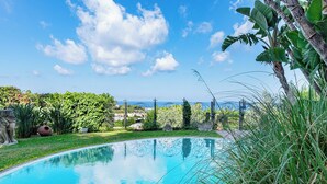 A swimming pool with a view of the sea and a clear sky. - Charming One-Bedroom Apartment with Sea View in Villa with Pool by the Sea (Forio)