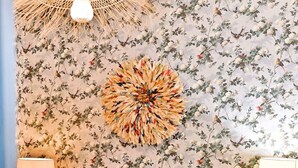 A bedroom with a bed, two bedside tables with lamps, a wall tapestry, and a hanging light fixture. - Superbe appartement lumineux 6P (Paris)