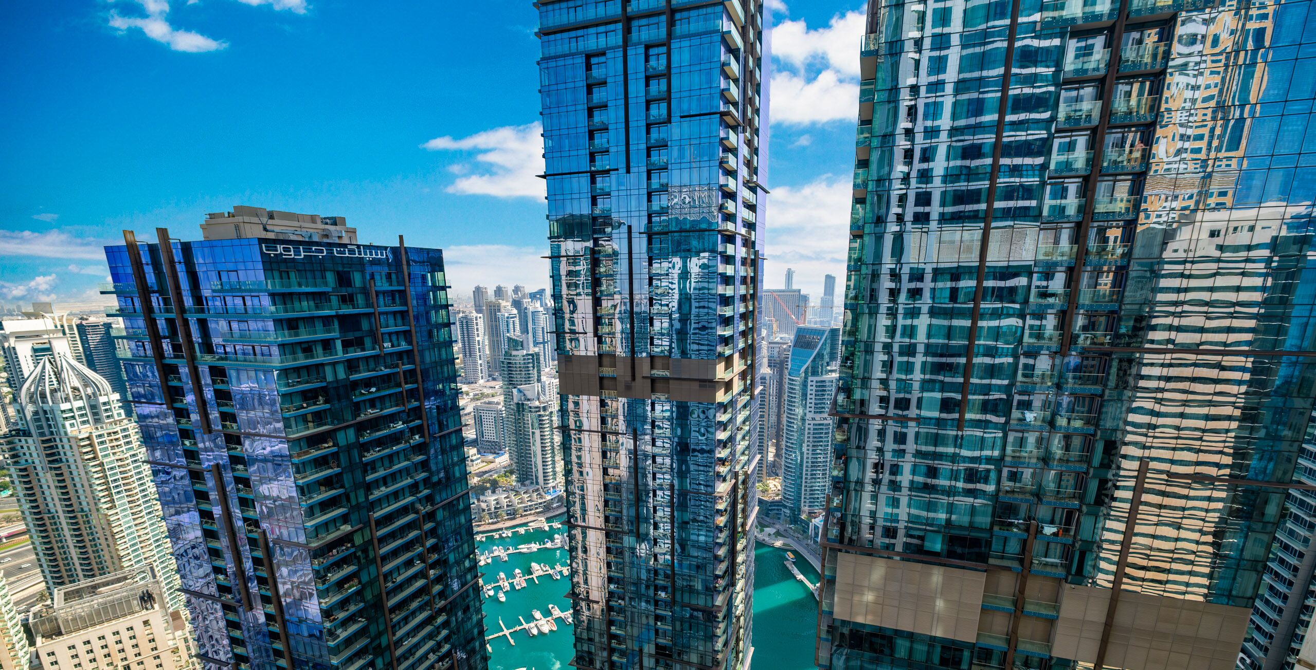 A high-rise building with a glass facade, surrounded by other tall structures.