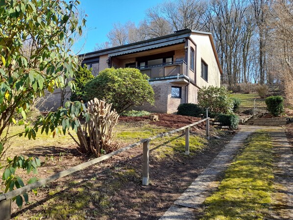 A modern house with a brick exterior, a balcony, and a pathway leading to the entrance. - Sorpesee/Amecke in Sauerland vacation home by the lake (Sundern (Sauerland))
