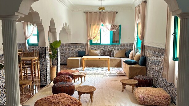 A spacious living area with a high ceiling, patterned walls, and a central seating arrangement. - Dar Al-Andalus (Tamraght)