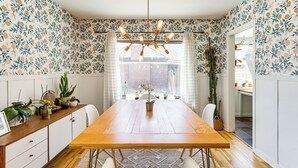 A dining area with a wooden table, white chairs, and a ceiling light fixture. - 24 Mi to Slopes! Family Reno Home w/ Outdoor Oasis (Reno)
