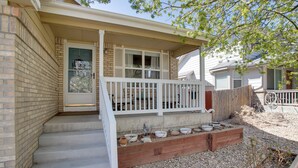 A residential house with a front porch, steps leading to the door, and a small garden area with planters. - 17 Mi to Dtwn Denver: Family Home w/ Private Yard (Commerce City)