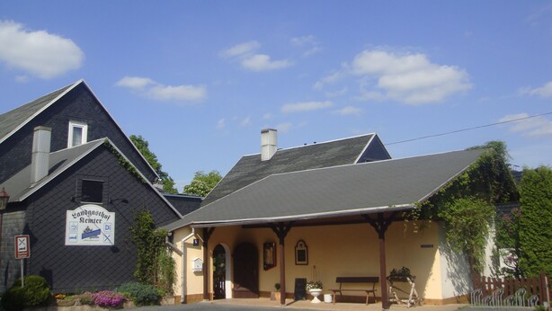Un bâtiment avec un toit sombre et une enseigne sur laquelle on peut lire « Landgasthof Hemmer ».