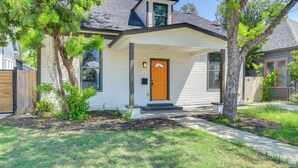 Une maison de plain-pied avec un porche à l’avant, une porte d’entrée bien visible et un petit jardin devant, agrémenté d’un arbre et de quelques arbustes.