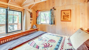 A wooden cabin bedroom with a bed, windows, and a framed picture on the wall. - 4 Mi to Lake Tahoe: Cozy Cabin w/ Deck! (South Lake Tahoe)
