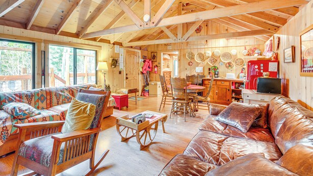 A spacious wooden cabin interior with a large sofa, a leather couch, and a dining area. - 4 Mi to Lake Tahoe: Cozy Cabin w/ Deck! (South Lake Tahoe)