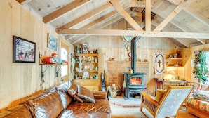 A cozy cabin interior with a leather sofa, wooden shelves, a fireplace, and a rocking chair. - 4 Mi to Lake Tahoe: Cozy Cabin w/ Deck! (South Lake Tahoe)