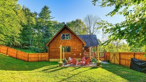 A wooden cabin with a deck and outdoor seating area. - Modern Comforts Classic Cabin: Family/fish Escape! (Deposit)