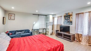 A modern hotel room with a large bed, a desk, a television, and a wardrobe. - 3 Mi to Dtwn Tacoma: Pet-friendly Home (Tacoma)
