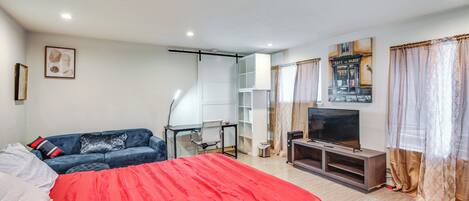 A modern hotel room with a large bed, a desk, a television, and a wardrobe.