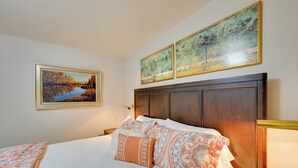A neatly made bed with patterned bedding, a wooden headboard, and two framed landscape paintings above it. - 2 Mi to Bitterroot River: Downtown Corvallis Apt! (Corvallis)