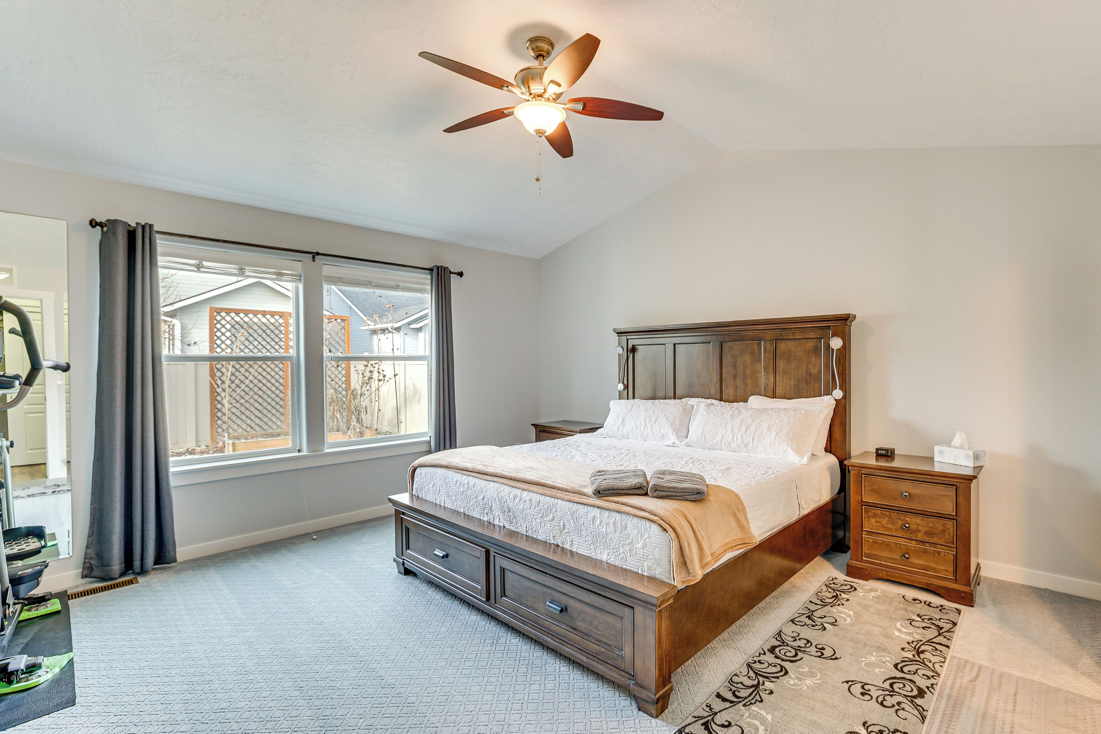 A bedroom with a bed, nightstand, and ceiling fan.