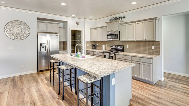 A modern kitchen with a central island, stainless steel appliances, and light-colored cabinetry. - Kuna Group Getaway w/ Patio & Grill (Kuna)
