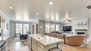 A spacious living area with a large island, a fireplace, and a television. - Kuna Group Getaway w/ Patio & Grill (Kuna)