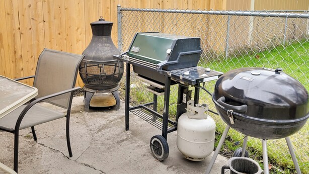 A backyard with a portable grill, a gas tank, and a table with chairs. - 2 Mi to Fly Fishing: Bbq-ready Corvallis Apartment (Corvallis)