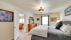 A bedroom with a bed, dresser, and artwork on the walls.