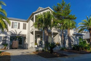 A two-story house with a covered porch, a garage, and a driveway. - Aquamarine in The Preserve at Grayton - Included Golf Cart, Close to Pool! (Santa Rosa Beach)