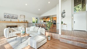 A spacious living room with a sofa set, a coffee table, and a potted plant. - Spacious Retreat With Scenic Mountain Views (Santa Ana)