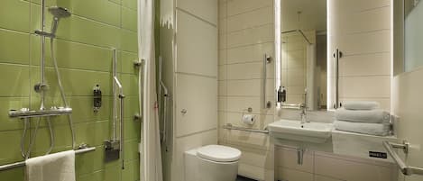 A bathroom with a shower, toilet, sink, and a mirror.
